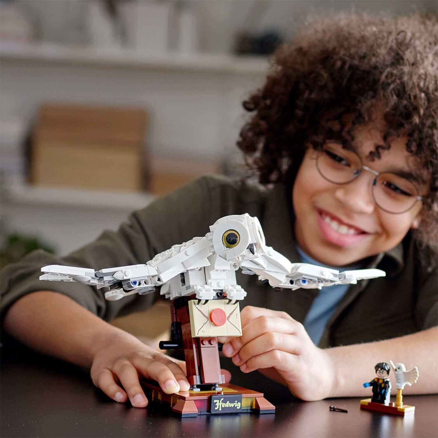 Child builds LEGO® Harry Potter Hedwig display set with realistic wings and Harry Potter mini-figure.