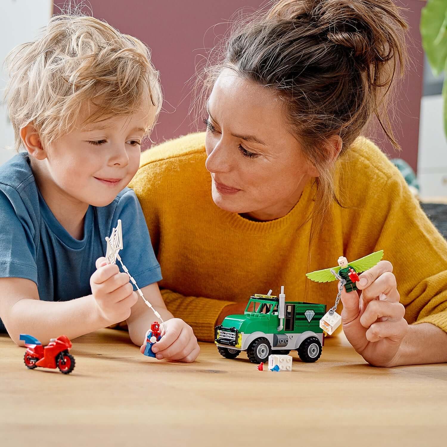 Child and mother enjoying LEGO® Marvel Spider-Man Trucker Robbery Set, playing with Spider-Man and Vulture figures.