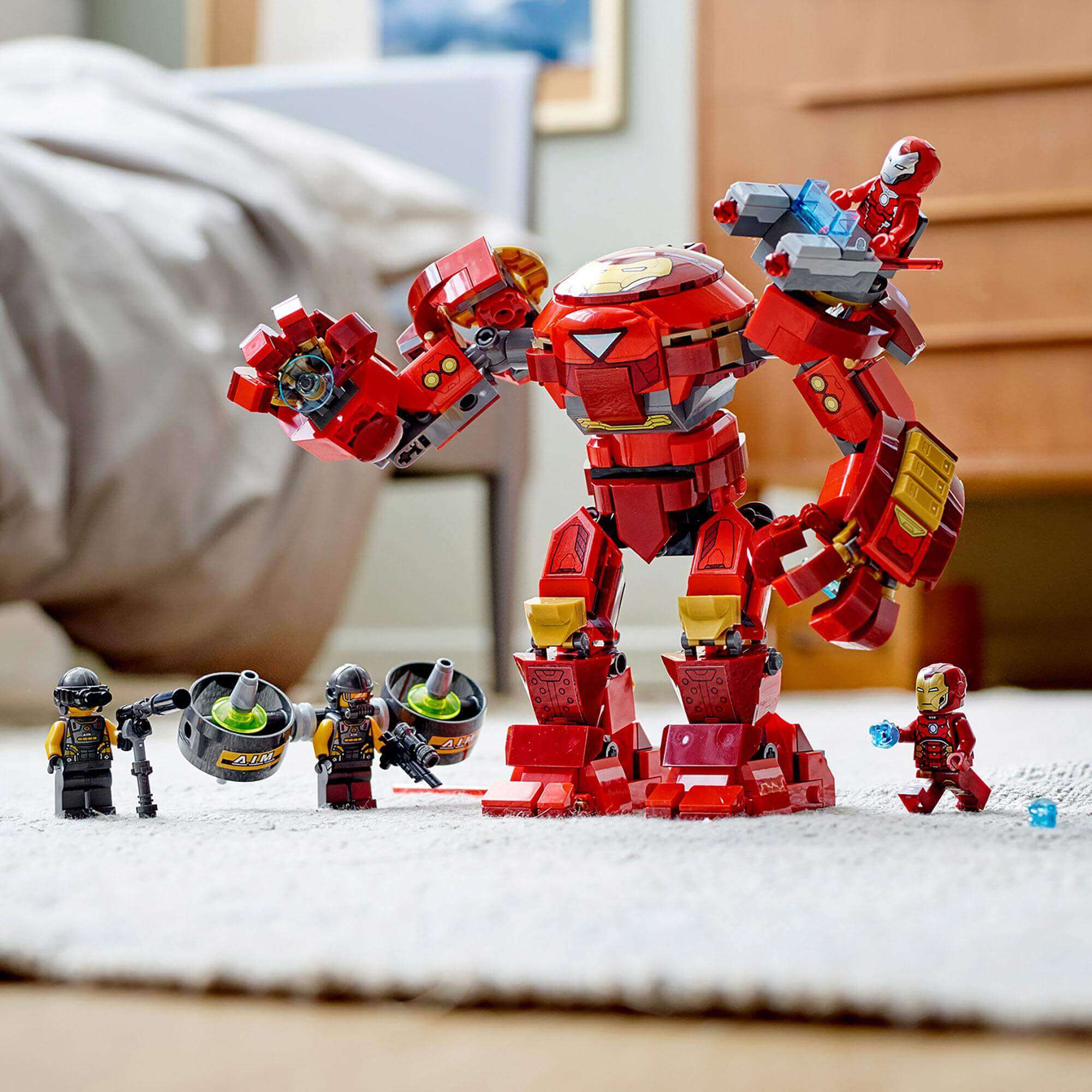LEGO Marvel Iron Man Hulkbuster set with movable limbs facing A.I.M. agents on a rug. Ideal for imaginative play.