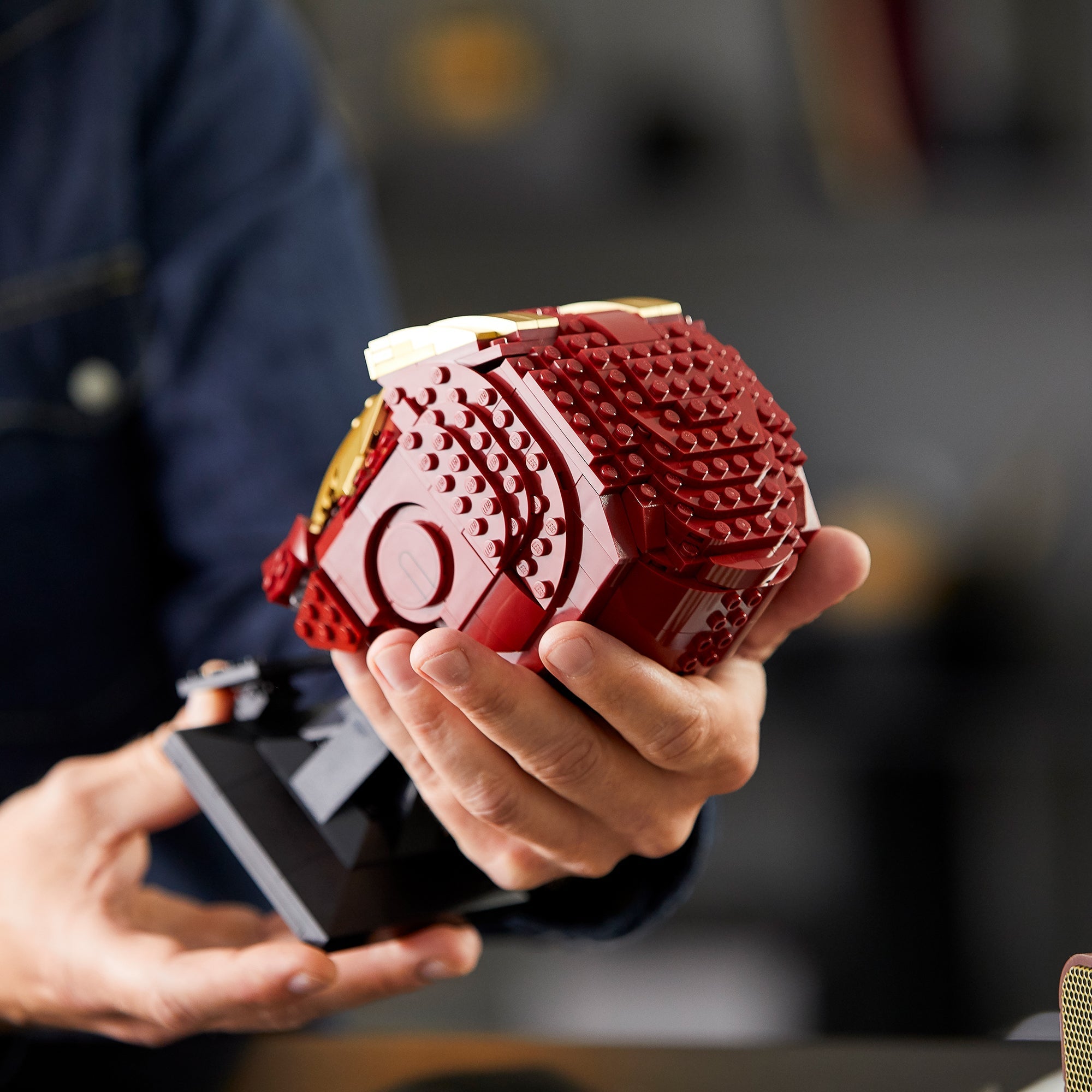 Person holding the LEGO® Marvel Iron Man Helmet 76165, showcasing its detailed brick design for adult Marvel fans.