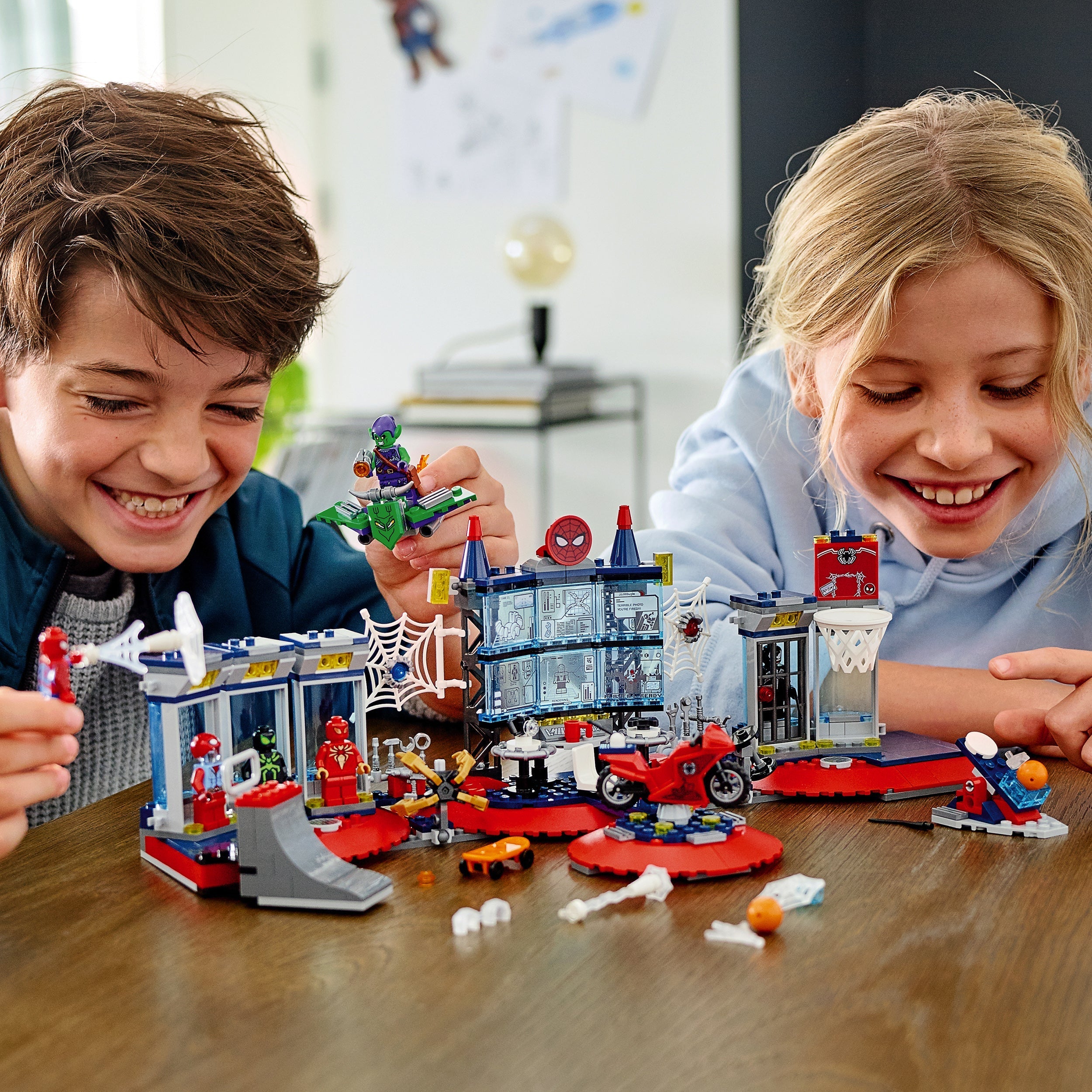 Kids enjoying LEGO® Marvel Spider-Man Attack on the Spider Lair set, featuring playful superhero action.