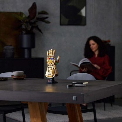 LEGO Marvel Infinity Gauntlet Thanos set on a table with a woman reading in a stylish, modern living space.