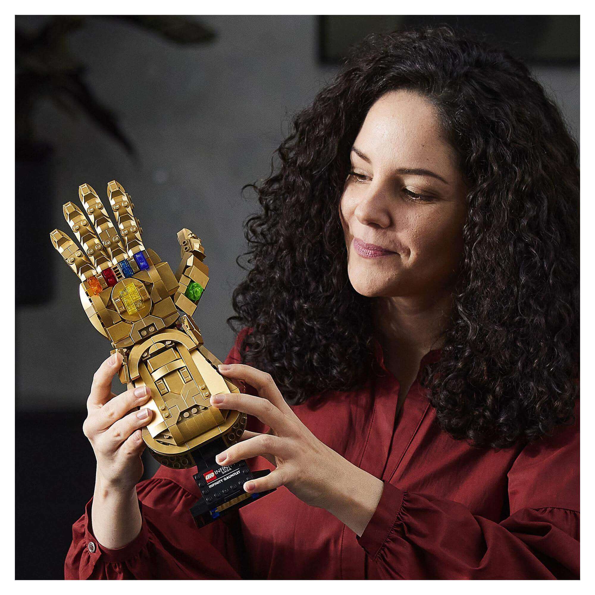 Adult woman holding LEGO Marvel Infinity Gauntlet Thanos set with six colorful Infinity Stones.