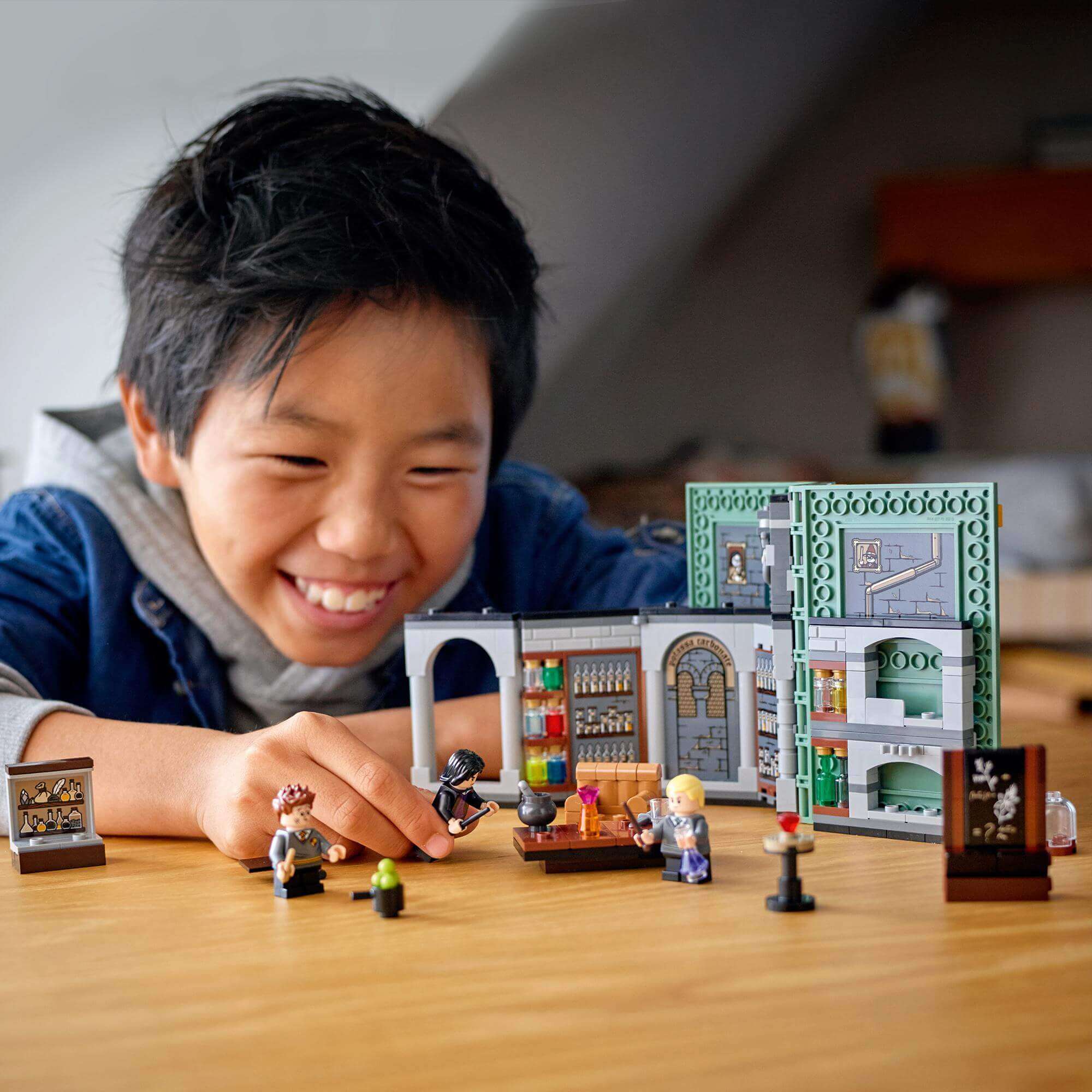 Child enjoying the LEGO® Harry Potter Potions Class set, featuring magical scenes and characters from Hogwarts.