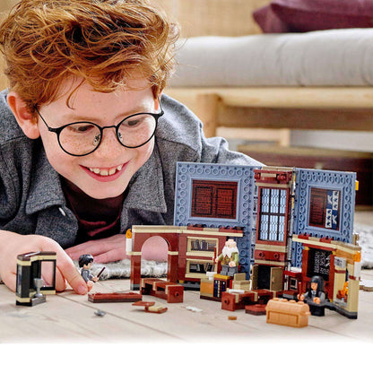 Child joyfully interacting with LEGO® Harry Potter Hogwarts Charms Class Set 76385, featuring a magical classroom design.