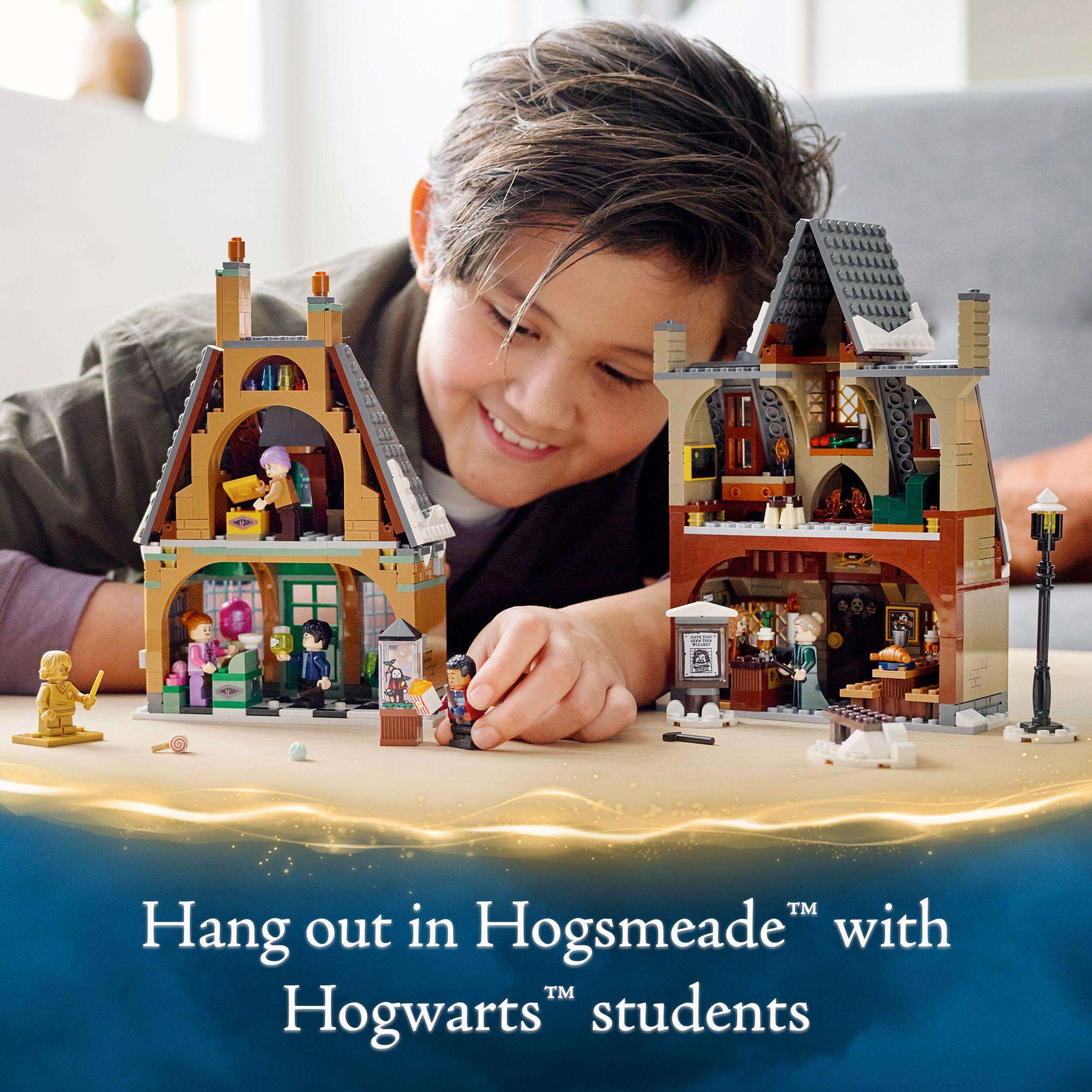 Child interacting with LEGO Harry Potter Hogsmeade Village Set featuring Hogwarts students, ideal for magical roleplay.