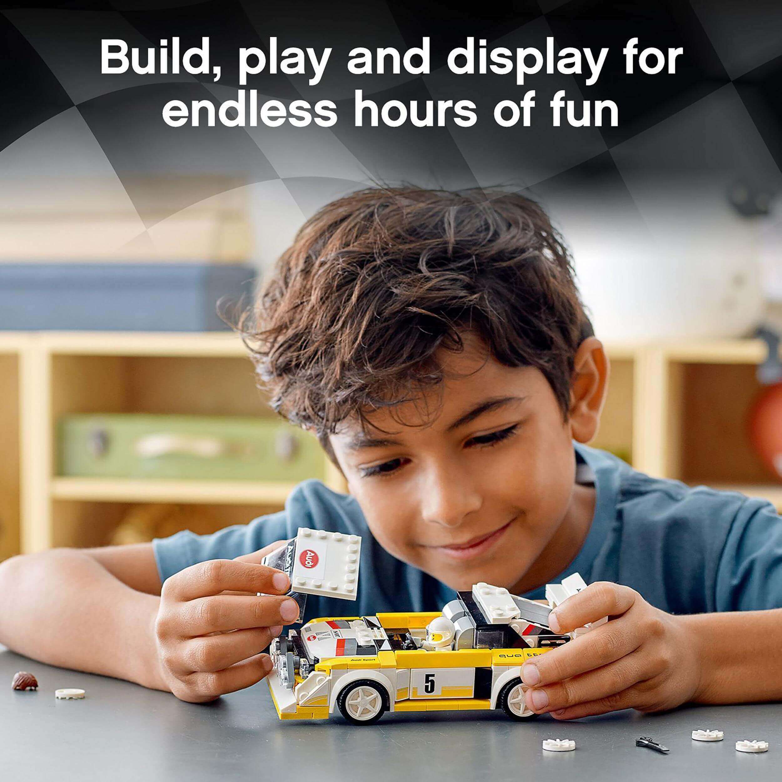 Boy building a LEGO Audi Speed Champions model, showcasing the fun of play and display for race fans.