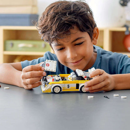 Child playing with LEGO® Speed Champions Audi Sport Quattro S1 model, showcasing creativity and building fun.