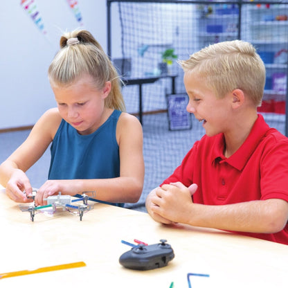 Two kids assembling a drone from a Maker Kit, engaging in STEM education and hands-on learning.