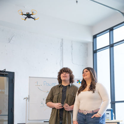 Students observing an Echo Drone flying indoors, showcasing aerial technology in a learning environment.