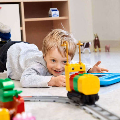 Child engaging with LEGO® Education Coding Express train set, learning coding concepts through play.