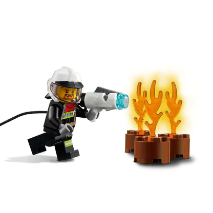 LEGO® firefighter with water sprayer tackling flames from a fire hazard truck playset, perfect for kids' imaginative play.