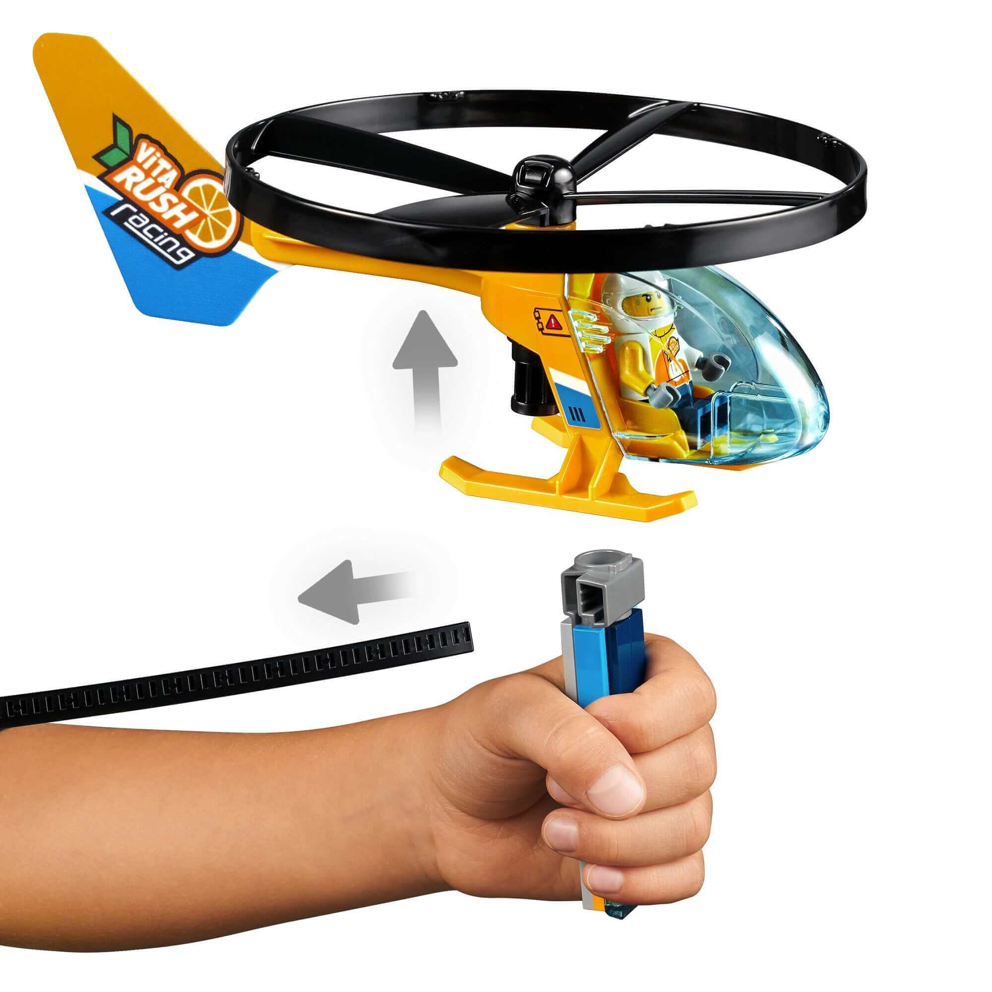 Child launching a LEGO® City Air Race toy helicopter with ripcord, featuring a minifigure pilot flying high.