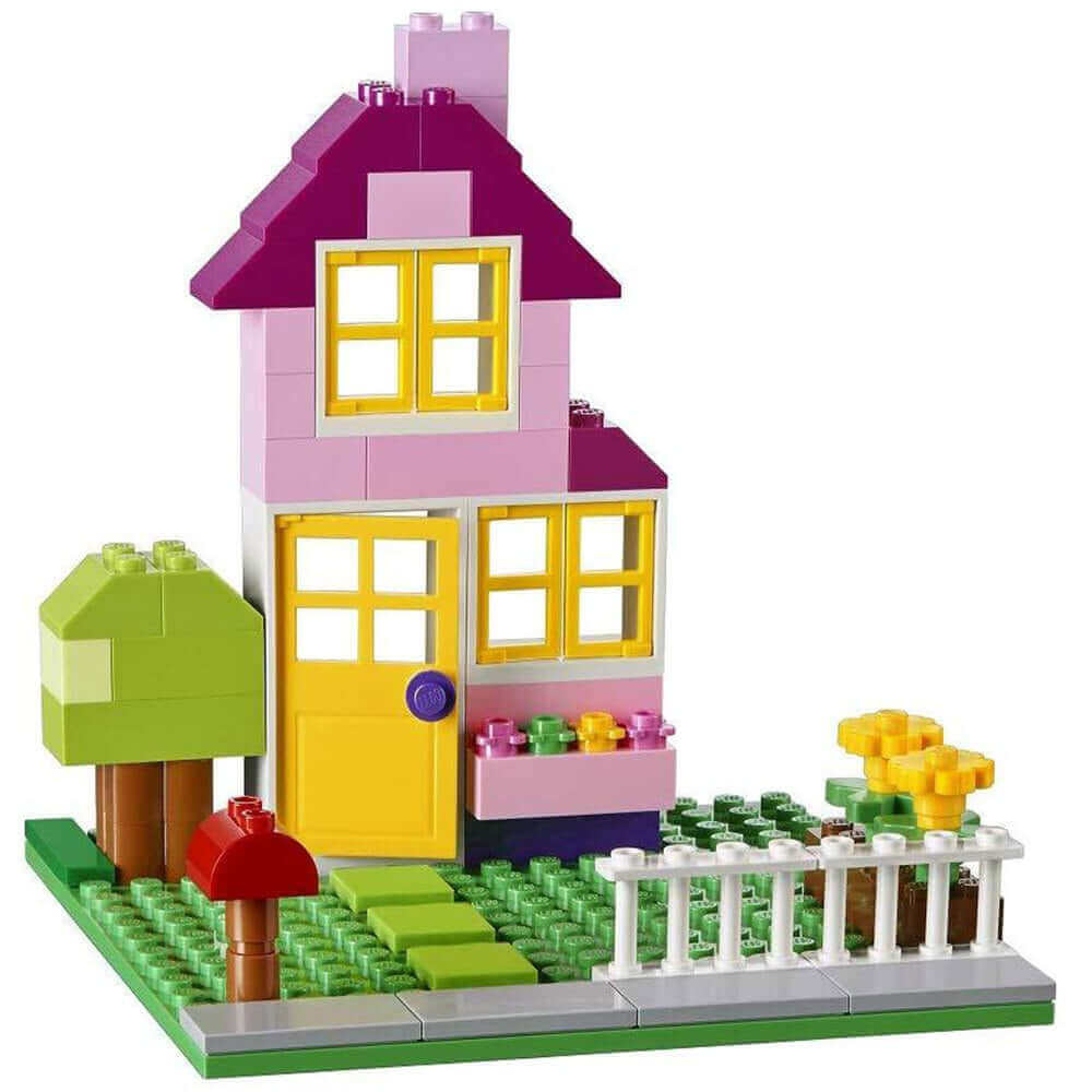 Colorful LEGO house model with purple roof, yellow door, and garden, showcasing creativity and building fun.