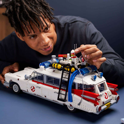 Person assembling LEGO® Creator Expert Ghostbusters ECTO-1 model, showcasing details and creativity.