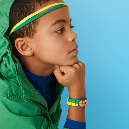 Young boy wearing a colorful DOTS bracelet and headband, showcasing creativity and sports enthusiasm.