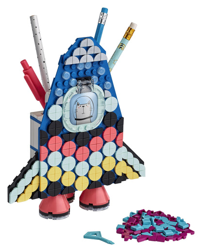 Colorful LEGO® DOTS Pencil Holder Craft Set shaped like a rocket, featuring various pens and vibrant tiles for creativity.