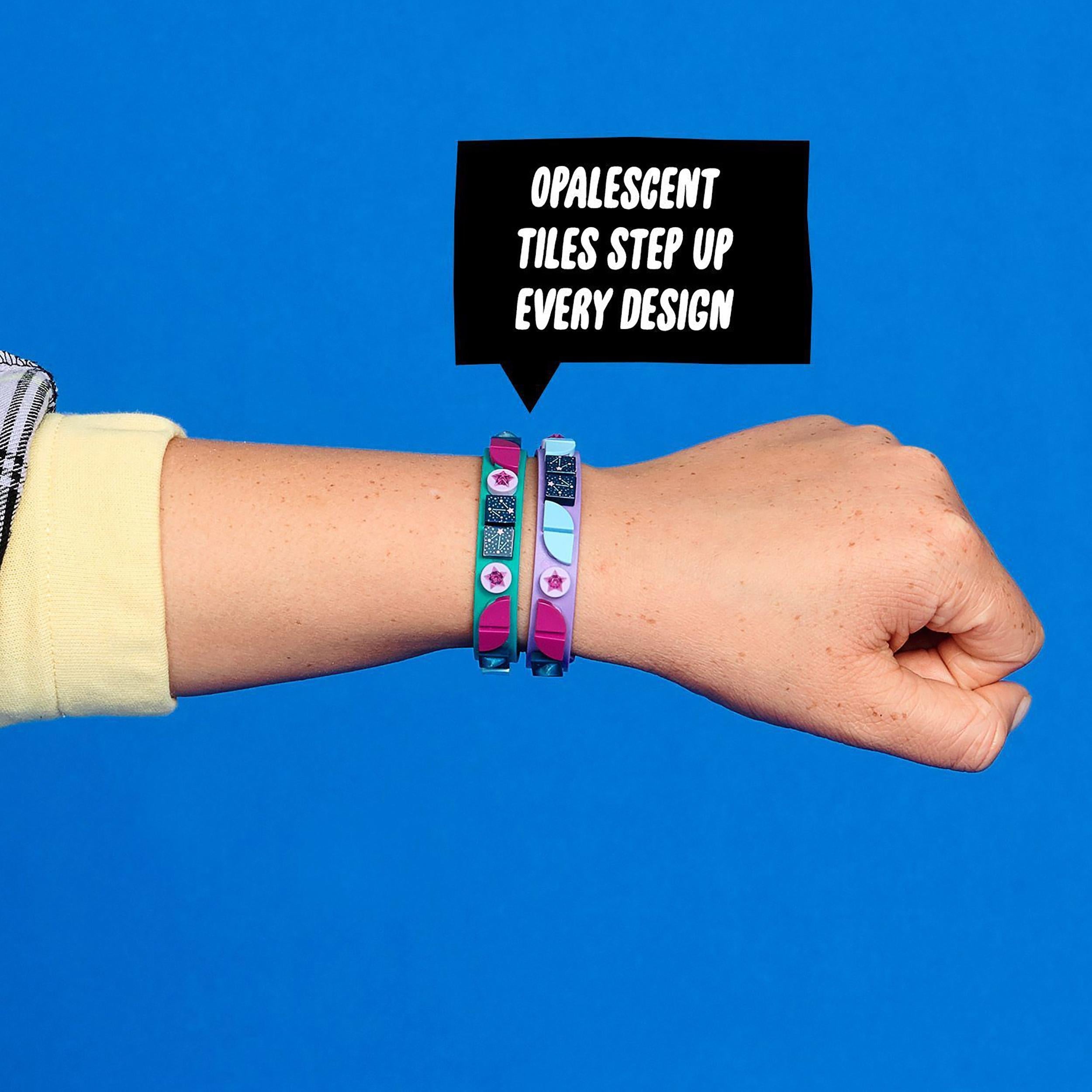 Child's hand wearing LEGO DOTS Starlight Bracelets with opalescent tiles, showcasing vibrant teal and purple designs.