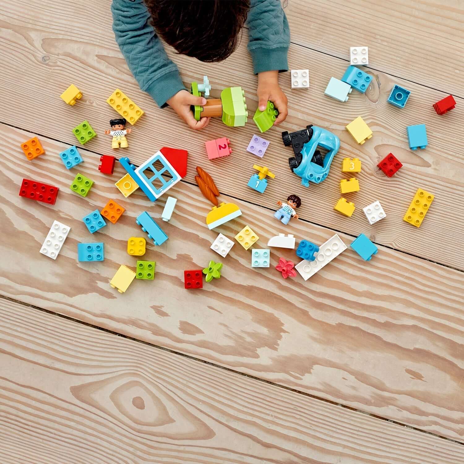 Child playing with colorful LEGO® DUPLO bricks, promoting creativity and developmental skills with the classic brick set.