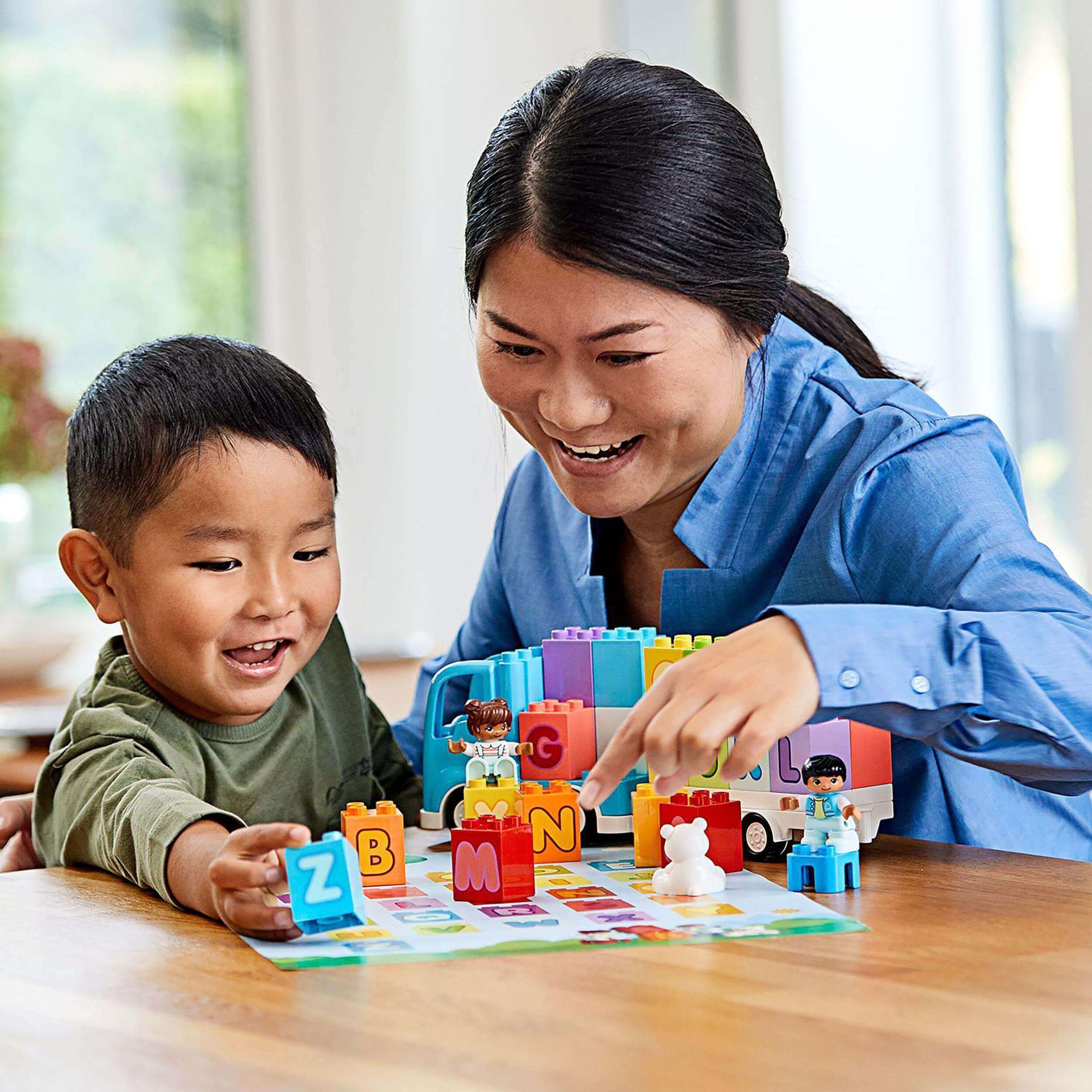 Mom and child playing with LEGO® DUPLO Alphabet Truck set, learning letters and enjoying creative play together.