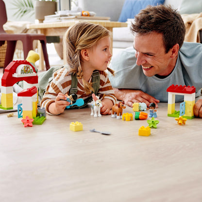 Father and daughter enjoying LEGO® DUPLO Town Horse Stable playtime with ponies and accessories.