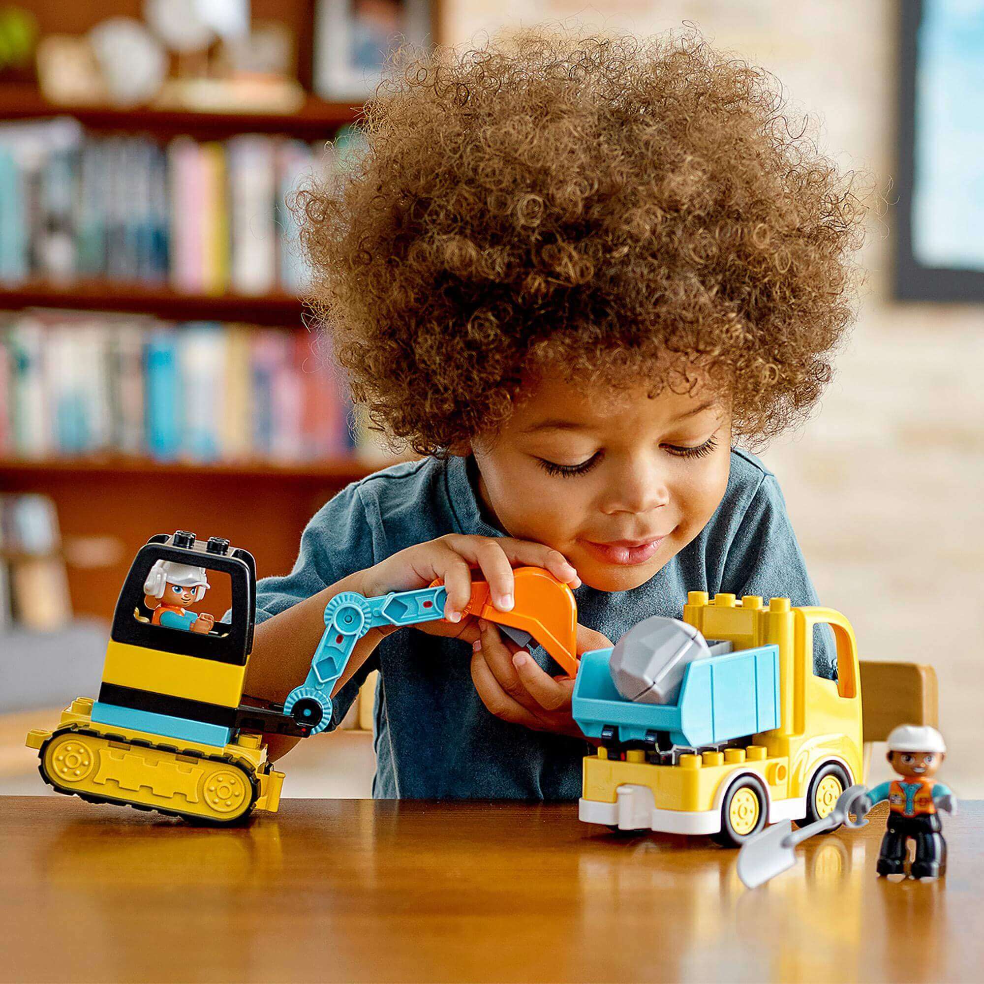 Child playing with LEGO® DUPLO Truck & Tracked Excavator set, fostering creativity and construction skills.