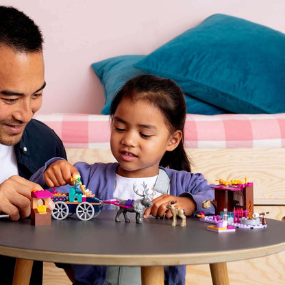 Child and adult enjoying LEGO Disney Frozen 2 Elsa's Wagon Adventure together at a play table.