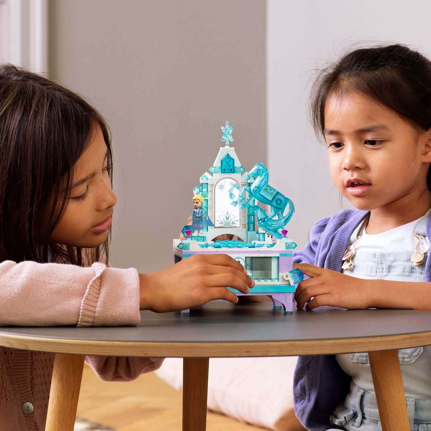 Kids playing with LEGO® Disney Frozen 2 Elsa's Jewellery Box Set 41168 on a table, showcasing creativity and fun.