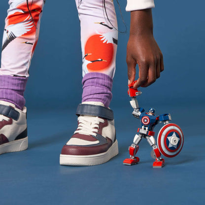 Child playing with LEGO Marvel Avengers Captain America mech toy, featuring movable limbs and detachable shield.