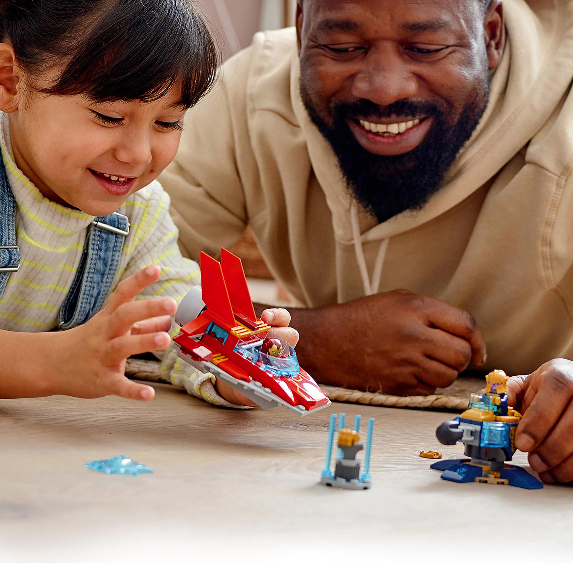 Child and adult playing with LEGO Marvel Avengers Iron Man vs. Thanos toy, creating epic battles and adventures.