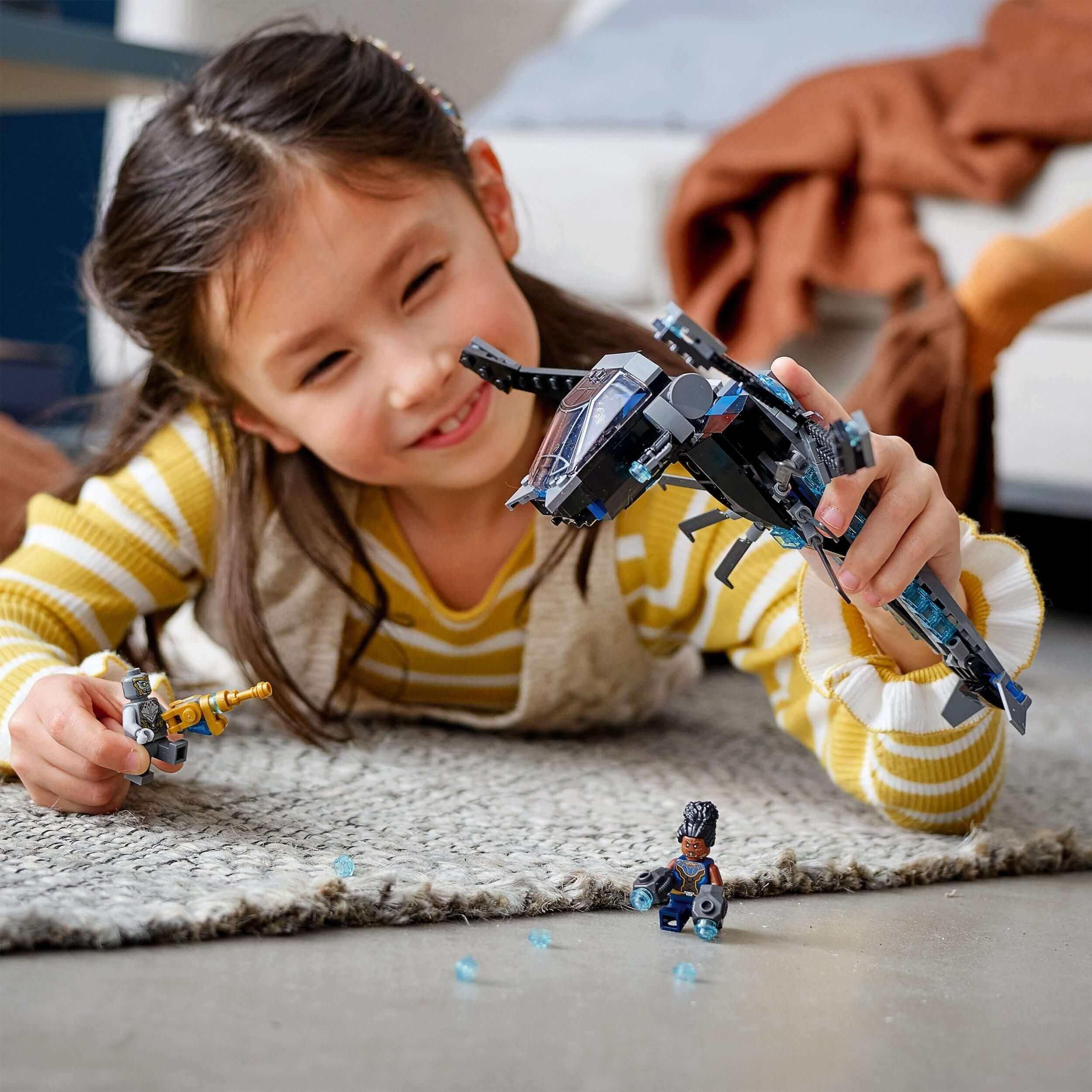 Girl playing with LEGO Marvel Black Panther Dragon Flyer set, showcasing superhero creativity and fun.