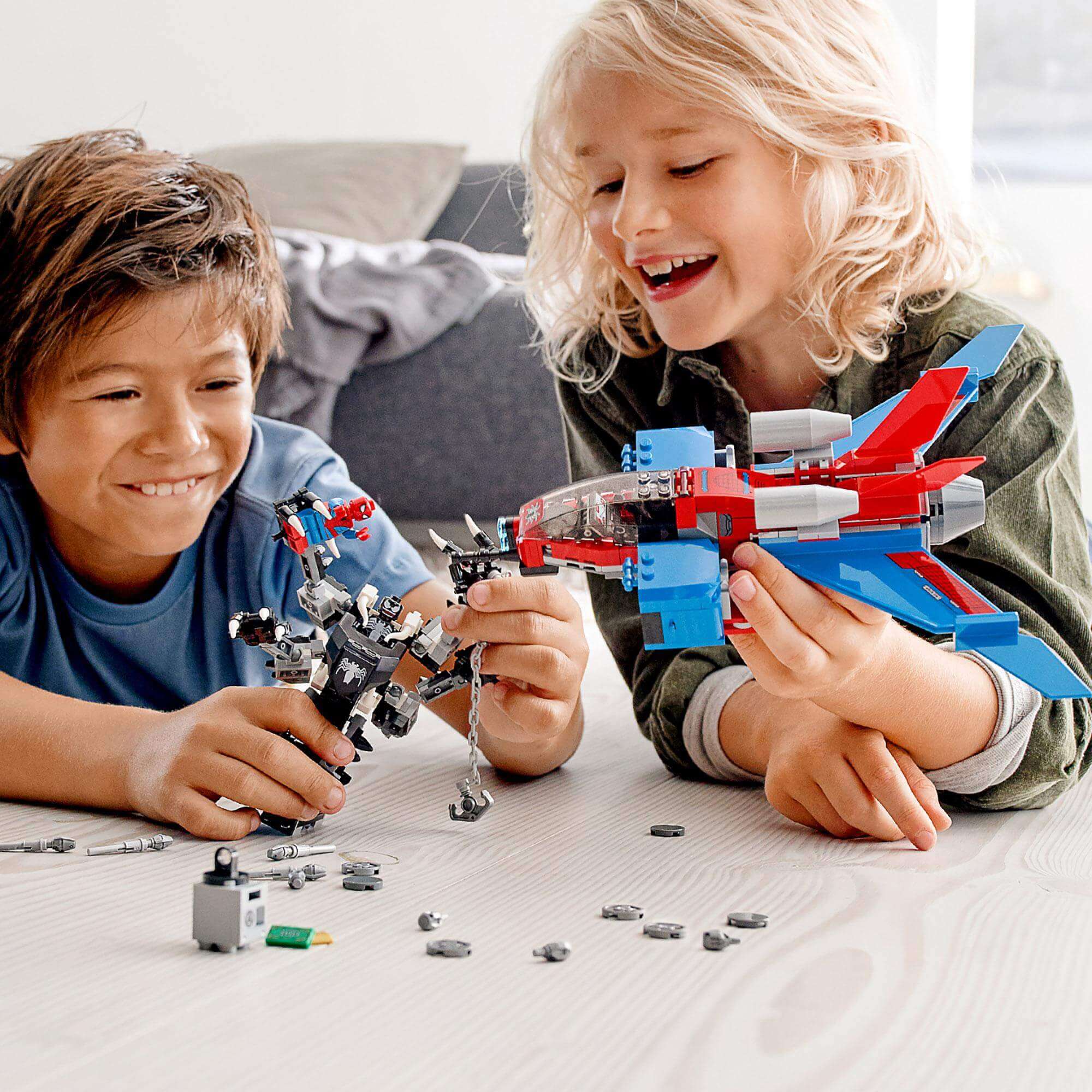 Kids playing with LEGO® Marvel Spider-Man Jet vs. Venom Mech Set 76150, featuring Spider-Man and Venom characters.