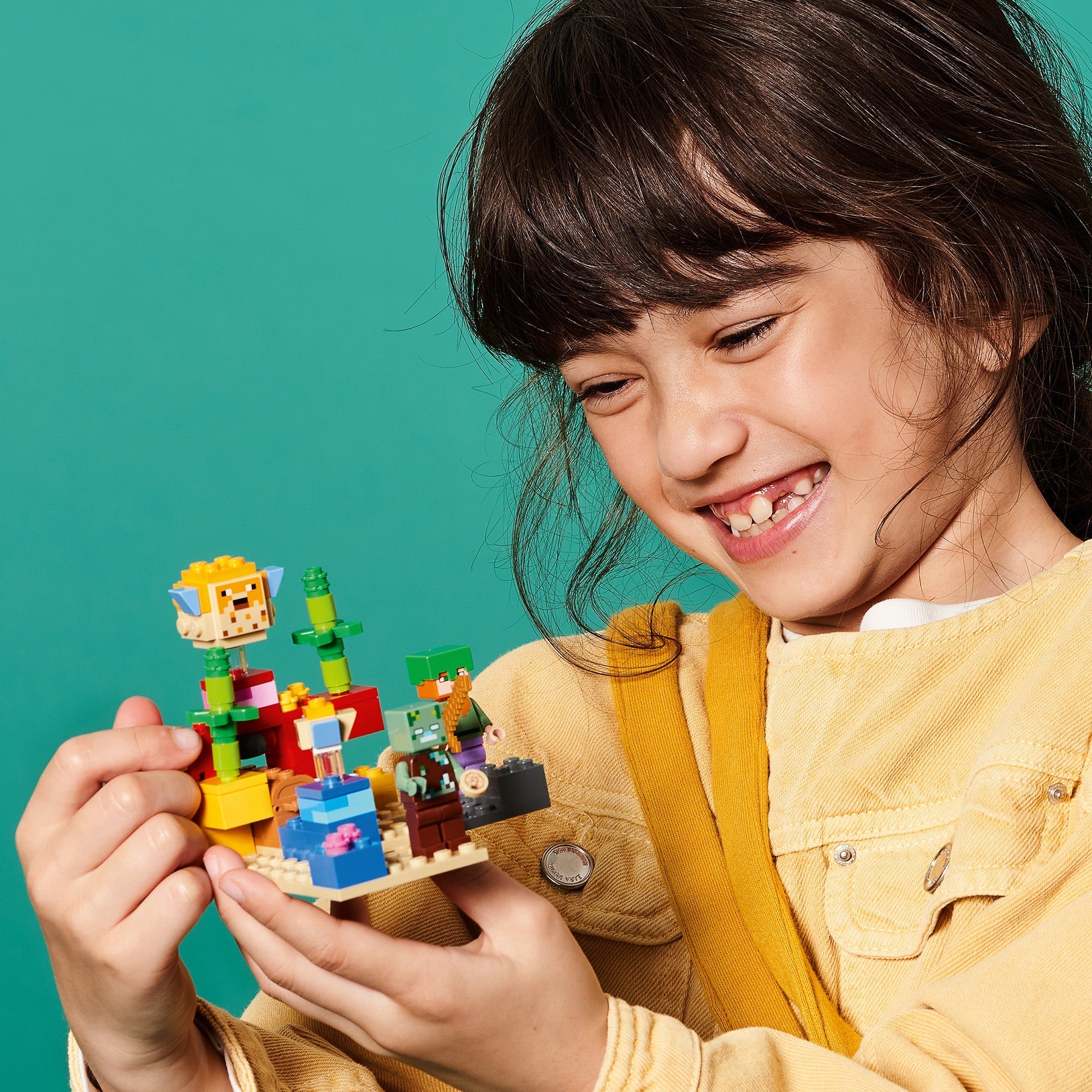 Child enjoying LEGO® Minecraft The Coral Reef set, showcasing creativity with colorful blocks and characters.
