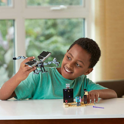 Child playing with LEGO® Minecraft The End Battle set 21151, showcasing creativity and fun in a bright room.