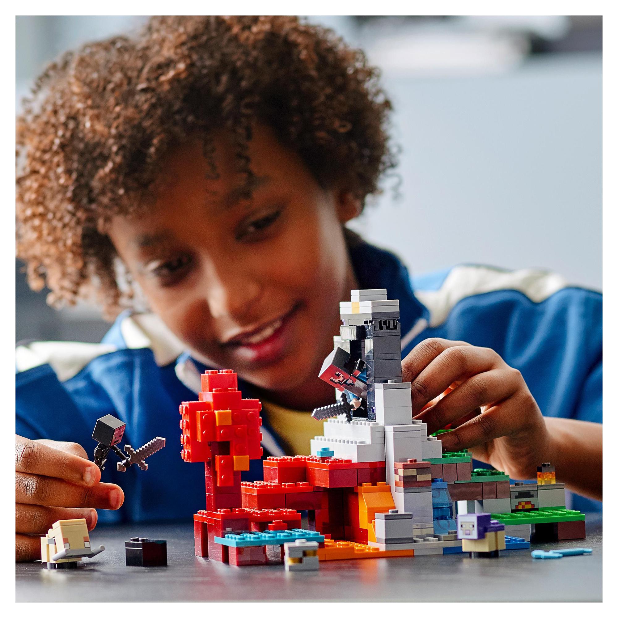 Child playing with LEGO® Minecraft The Ruined Portal set, crafting imaginative multidimensional adventures.
