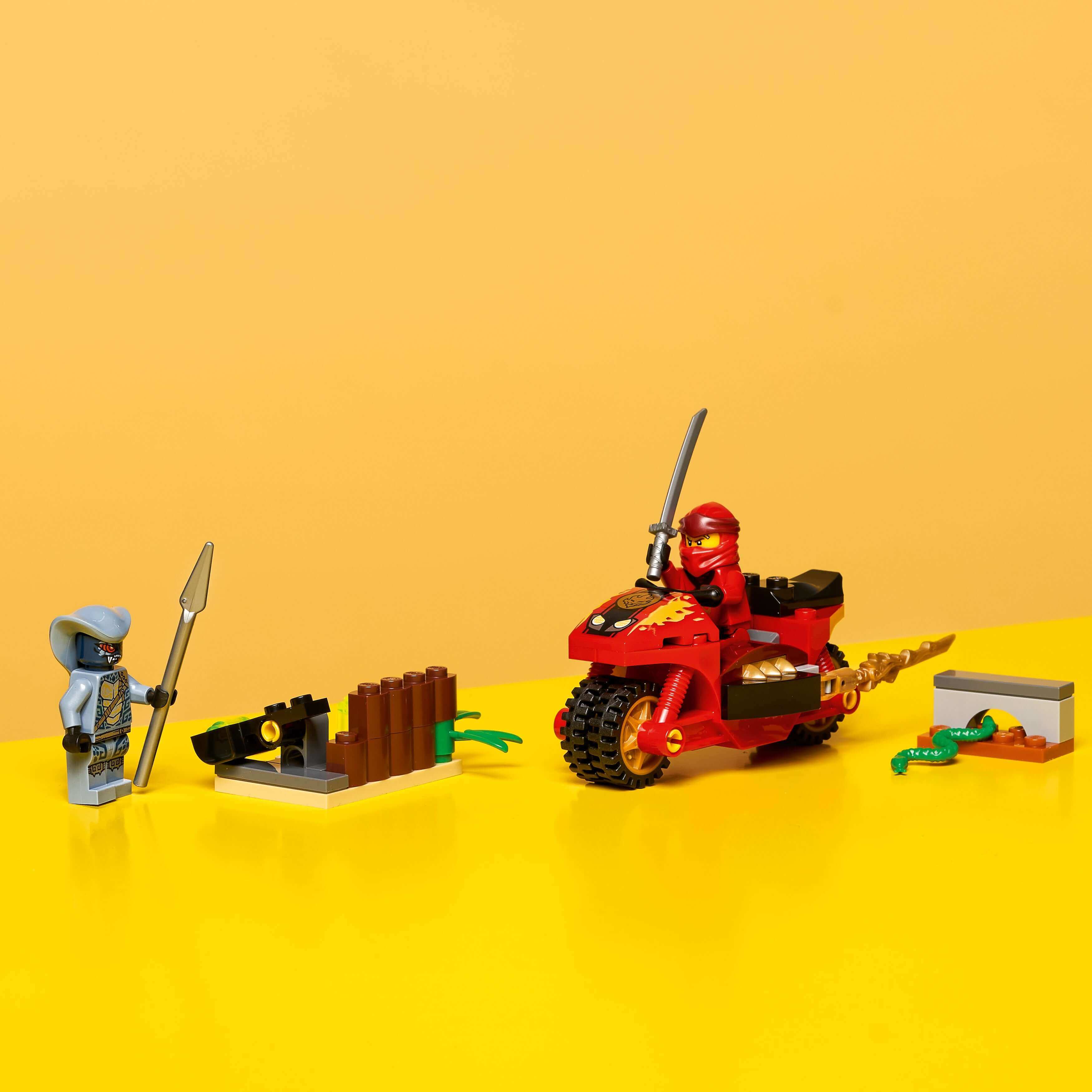 LEGO NINJAGO Legacy Kai’s Blade Cycle Set 71734 with motorcycle, ninja minifigures, and catapult on yellow background.