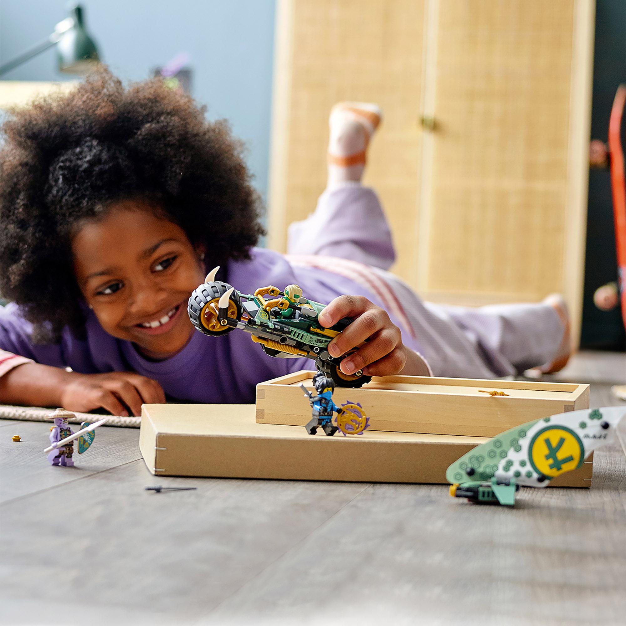 Child playing with LEGO NINJAGO Lloyd’s Jungle Chopper Bike Toy 71745 and surfboard, enjoying imaginative play.