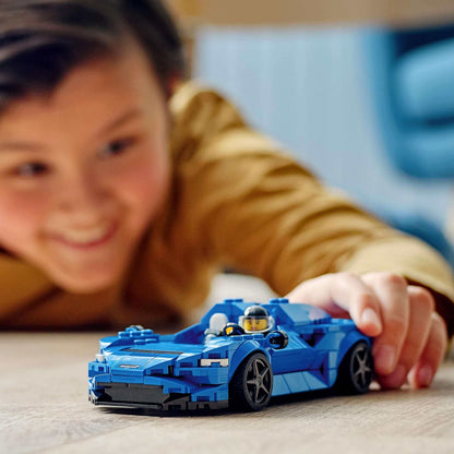Child playing with LEGO® Speed Champions McLaren Elva Race Car Toy 76902 on the floor.
