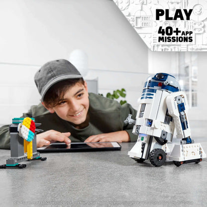 Kid playing with LEGO Star Wars BOOST Droid Commander, controlling R2-D2 and enjoying app missions.