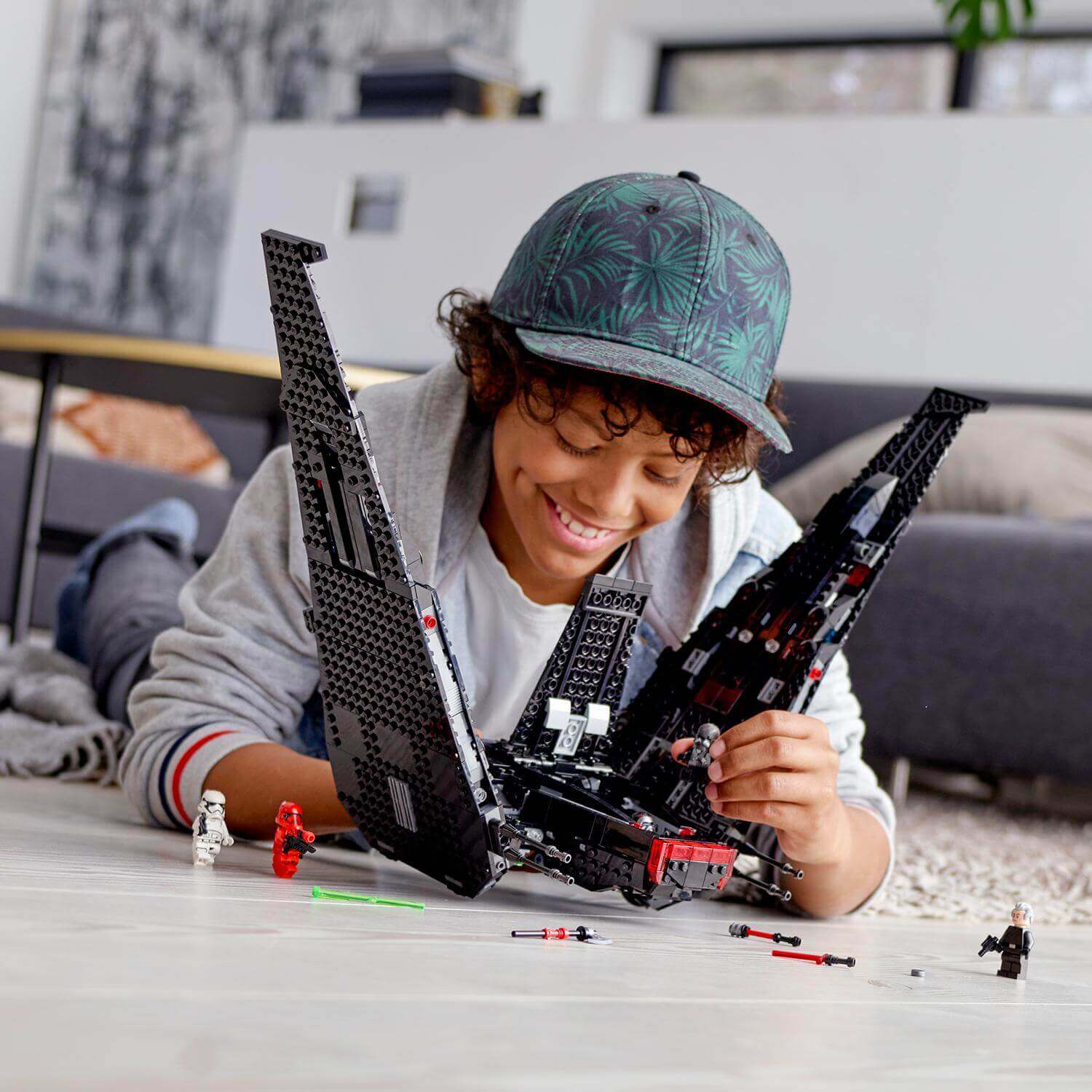 Child assembling LEGO Star Wars Kylo Ren's Shuttle set 75256, enjoying creative playtime.