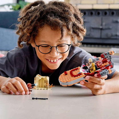 Young boy enjoying playtime with LEGO® Star Wars Luke Skywalker Landspeeder 75271, showcasing creativity and fun.
