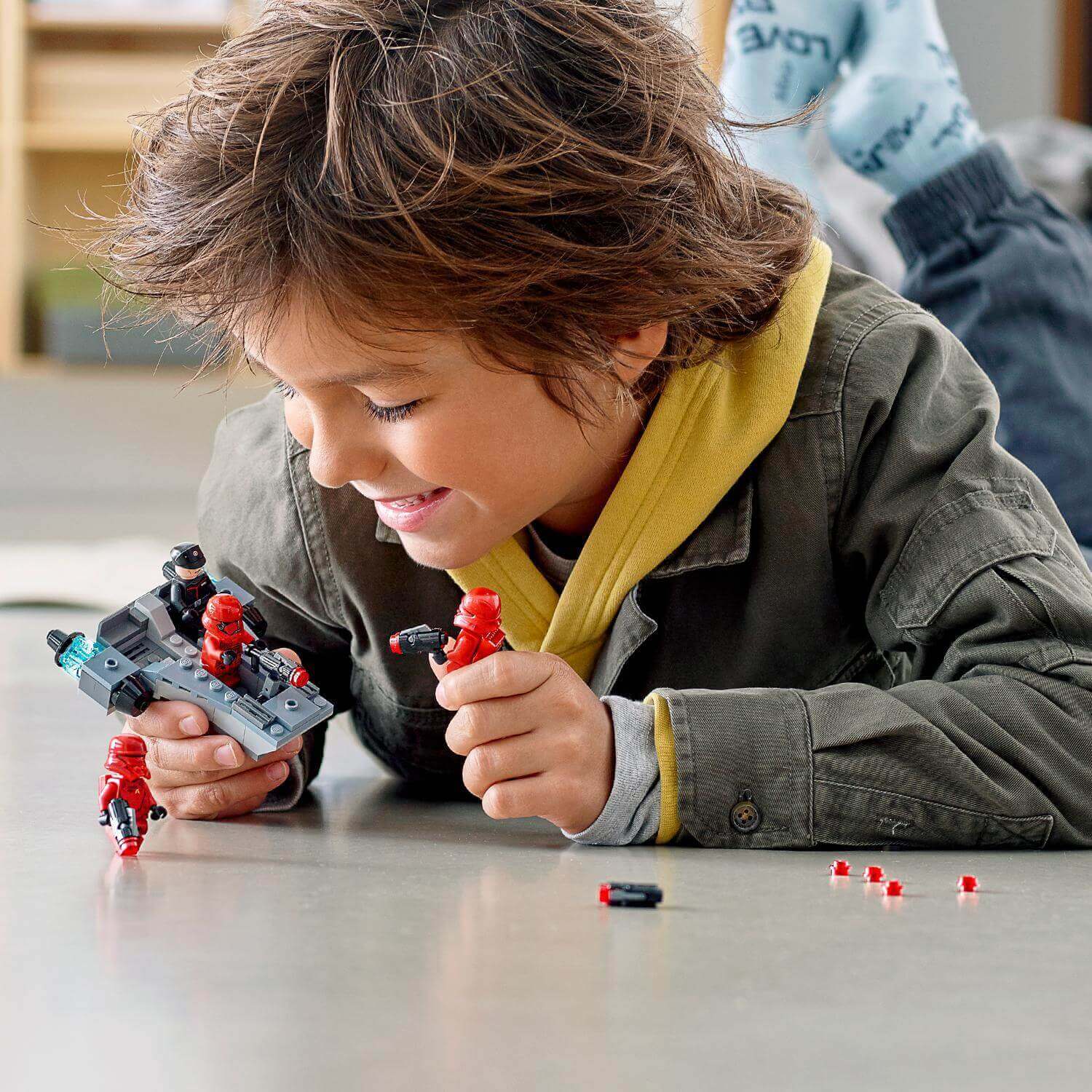 Child enjoying the LEGO® Star Wars Sith Troopers Battle Pack set, building and playing with First Order troopers.