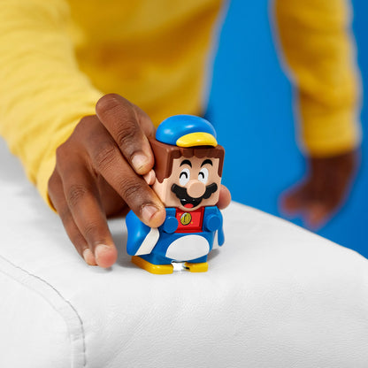 Child playing with LEGO® Super Mario Penguin Mario figure from the Power-Up Pack 71384 on a white surface.