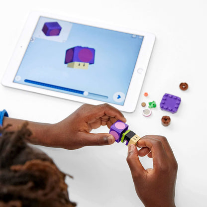Child assembling a LEGO® piece with a tablet screen showing a 3D model, enhancing creativity and play.