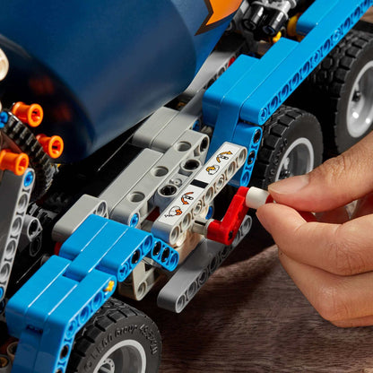 Child assembling LEGO® Technic Concrete Mixer Truck Toy 42112, showcasing building piece connections and details.