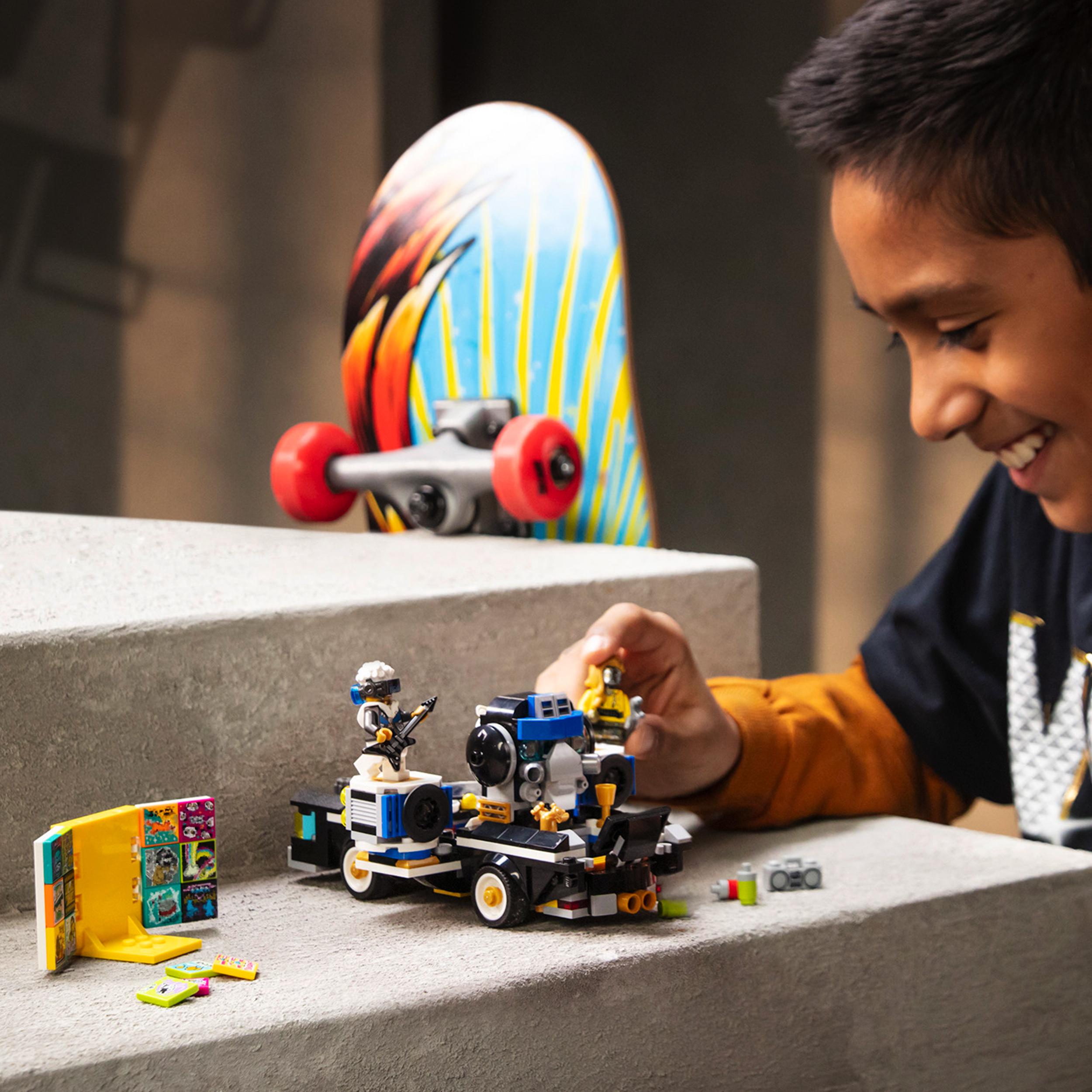 Child playing with LEGO® VIDIYO Robo HipHop Car BeatBox set, creating music videos with vibrant skateboard in background.