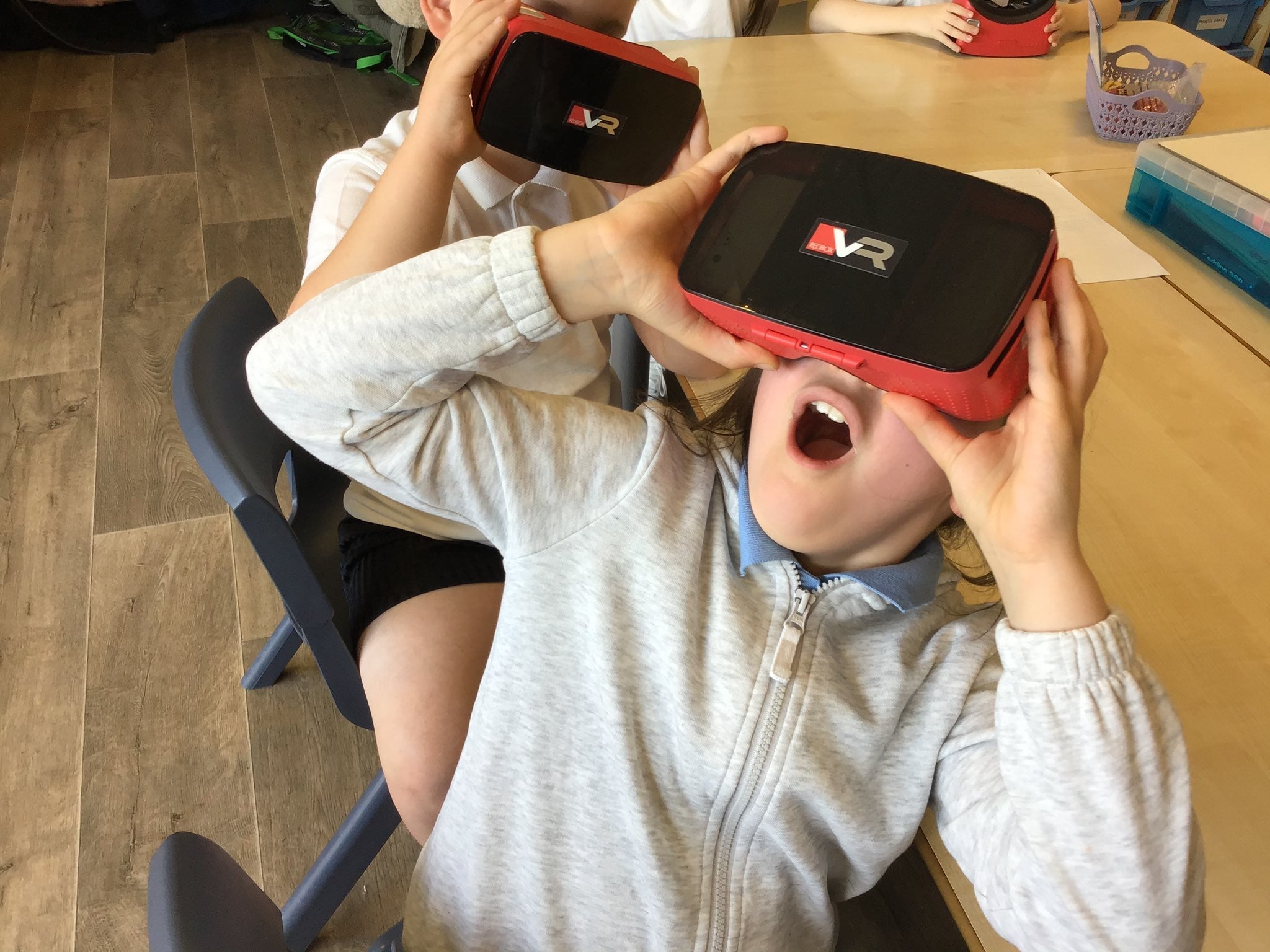 Students enjoying immersive learning with RedboxVR virtual reality viewers in a classroom setting.