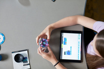 Student programming Sphero BOLT+ robot with tablet, showcasing interactive learning in education.