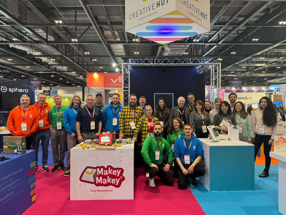 Group photo of Creative Hut team at a tech expo, showcasing Makey Makey and innovative projects.