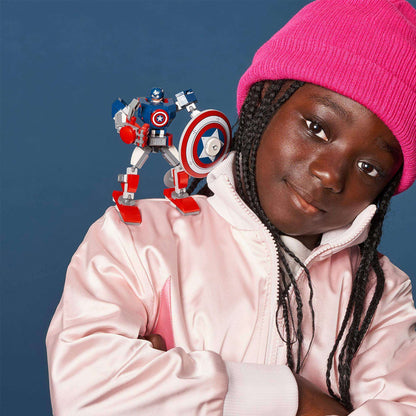 Young girl in pink hat with LEGO Captain America mech on her shoulder, ready for superhero adventures.